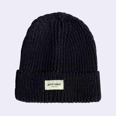 Black knit beanie with a small cream colored rectangle embroidered on the front that reads "Giant Robot" in cursive with "since 1994" below it in all caps.