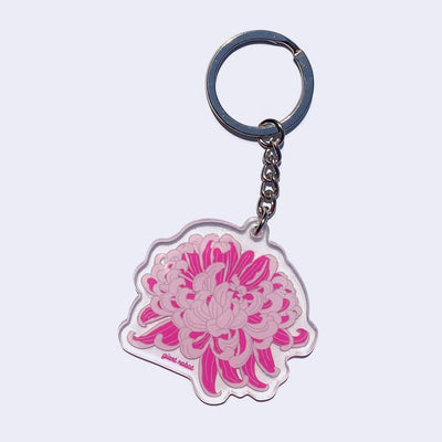 Clear die cut keychain of an illustrated blossoming pink and purple chrysanthemum. "Giant Robot" is written in small purple font on the bottom.