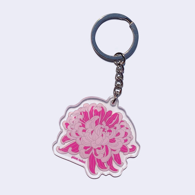 Clear die cut keychain of an illustrated blossoming pink and purple chrysanthemum. "Giant Robot" is written in small purple font on the bottom.