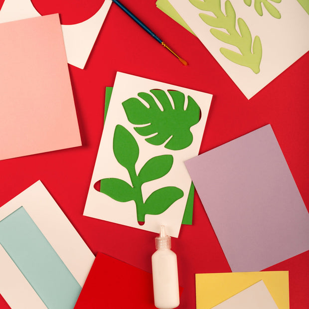 Stencil in the shape of 2 different leaves used to cut out of colored paper.