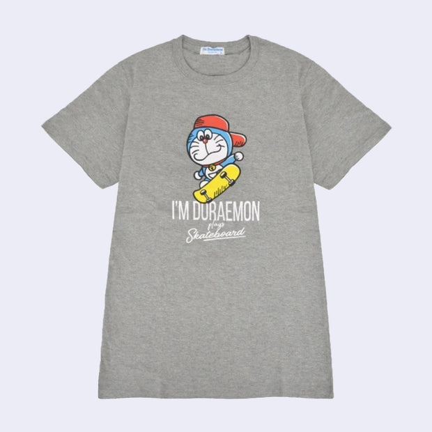 Gray t-shirt with an illustrated graphic of Doraemon, a blue earless cat character, wearing a backwards red hat and riding a yellow skateboard. Text reads "I'm Doraemon plays skateboard"