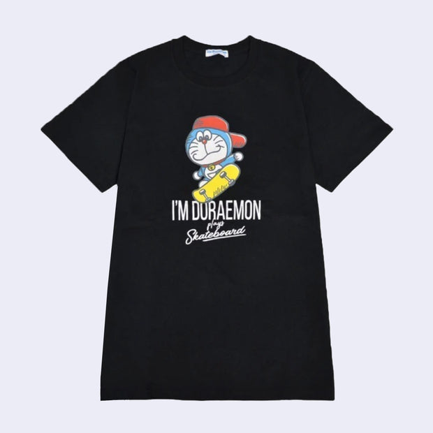 Black t-shirt with an illustrated graphic of Doraemon, a blue earless cat character, wearing a backwards red hat and riding a yellow skateboard. Text reads "I'm Doraemon plays skateboard"