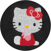Close up of embroidery of Hello Kitty, sitting on the ground and looking to the side with her hand over her mouth.