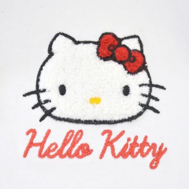 Close up of an embroidery of Hello Kitty's face with her iconic red bow and her name written in red cursive below.