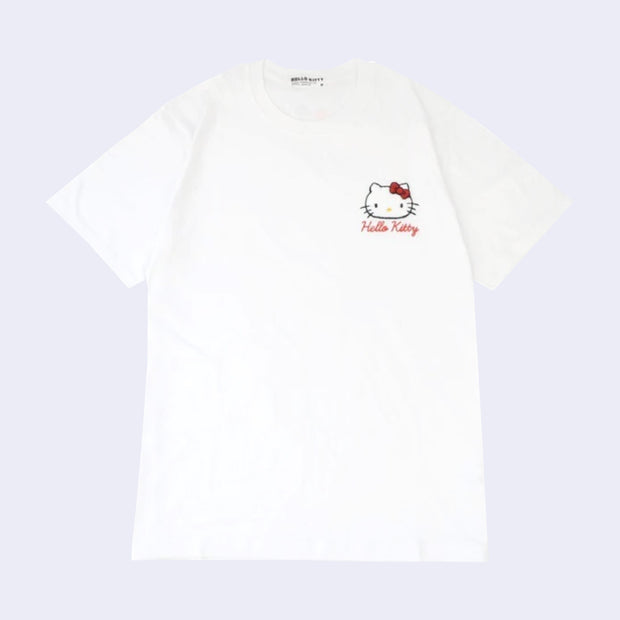White t-shirt with an embroidery on the upper left chest area of Hello Kitty's face with her iconic red bow and her name written in red cursive below.