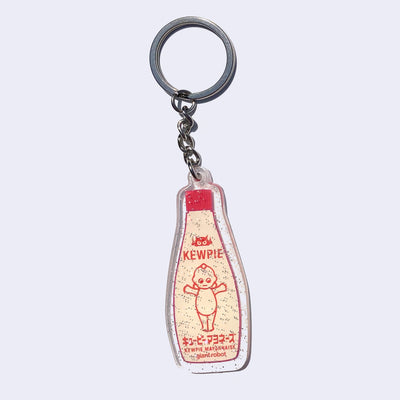 Die cut enamel pin of a bottle of Kewpie mayonnaise in illustrated style. Flecks of glitter cover the charm surface.