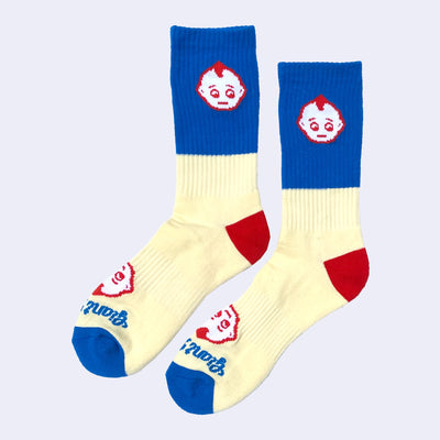 Pair of socks, mostly light yellow with a block of blue and red accents. A small kewpie head is on the ankle with another on the foot with "Giant Robot" written underneath.