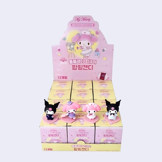 Product display of 4 small figures and their flat of product boxes.