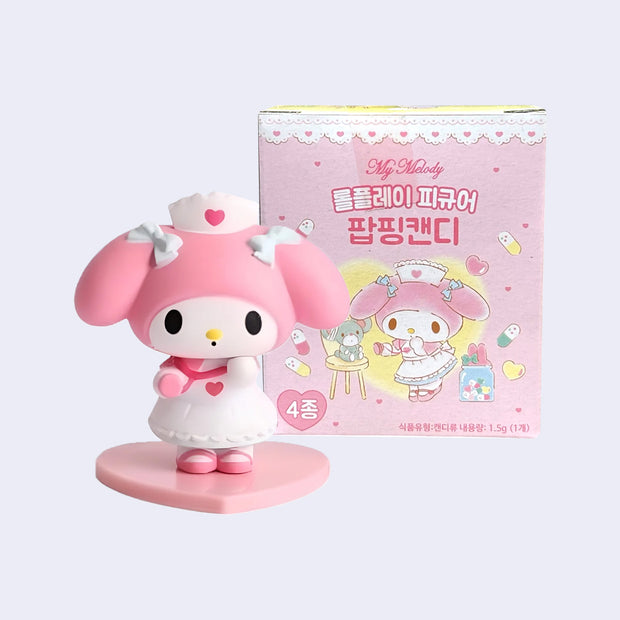 Plastic figure of My Melody, dressed as a nurse in a white dress and matching hat, each with a small heart icon. She has white bows in her hair and pink shoes.