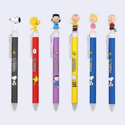 6 ballpoint click pens with "Peanuts" written along the body and different Peanuts characters atop the pen.